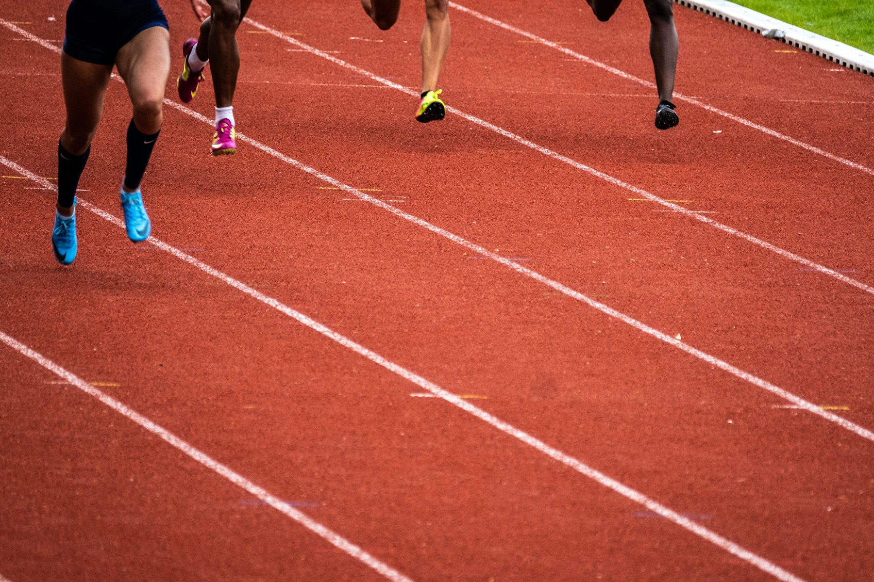 Runners mid-stride on a red athletics track